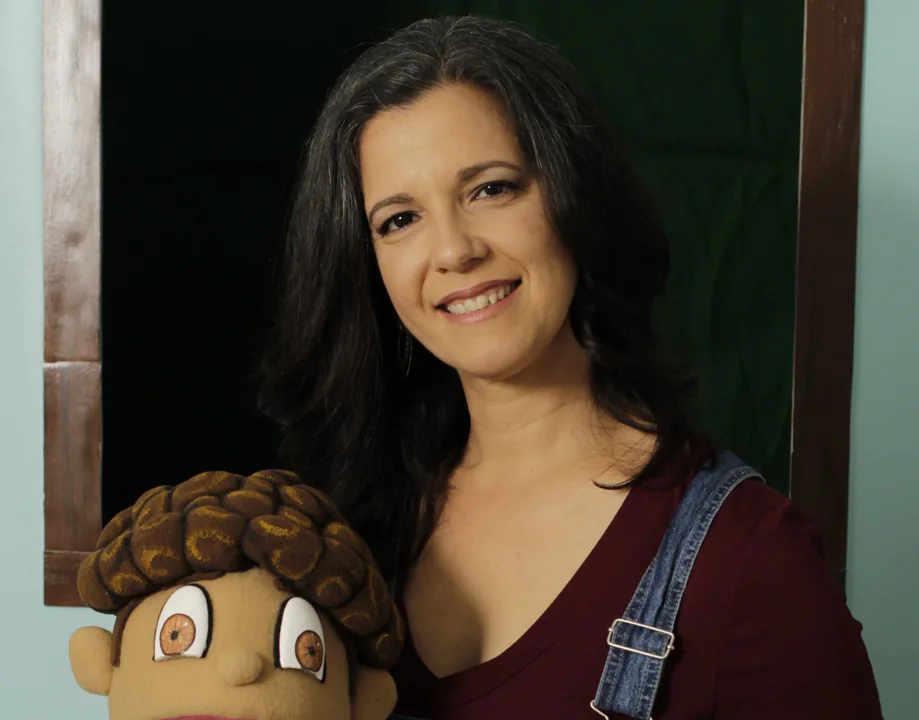 Artist holding a handmade character puppet